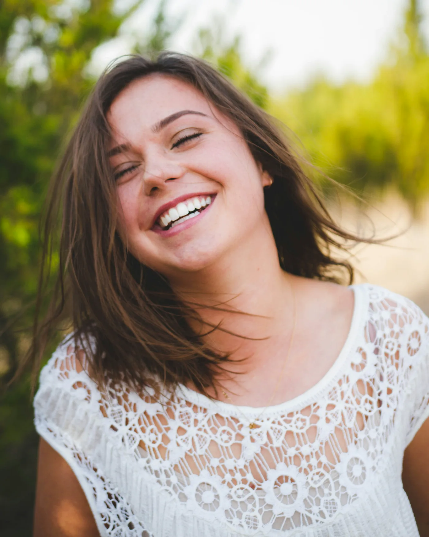 Patient laughing outdoors with a bright, healthy smile