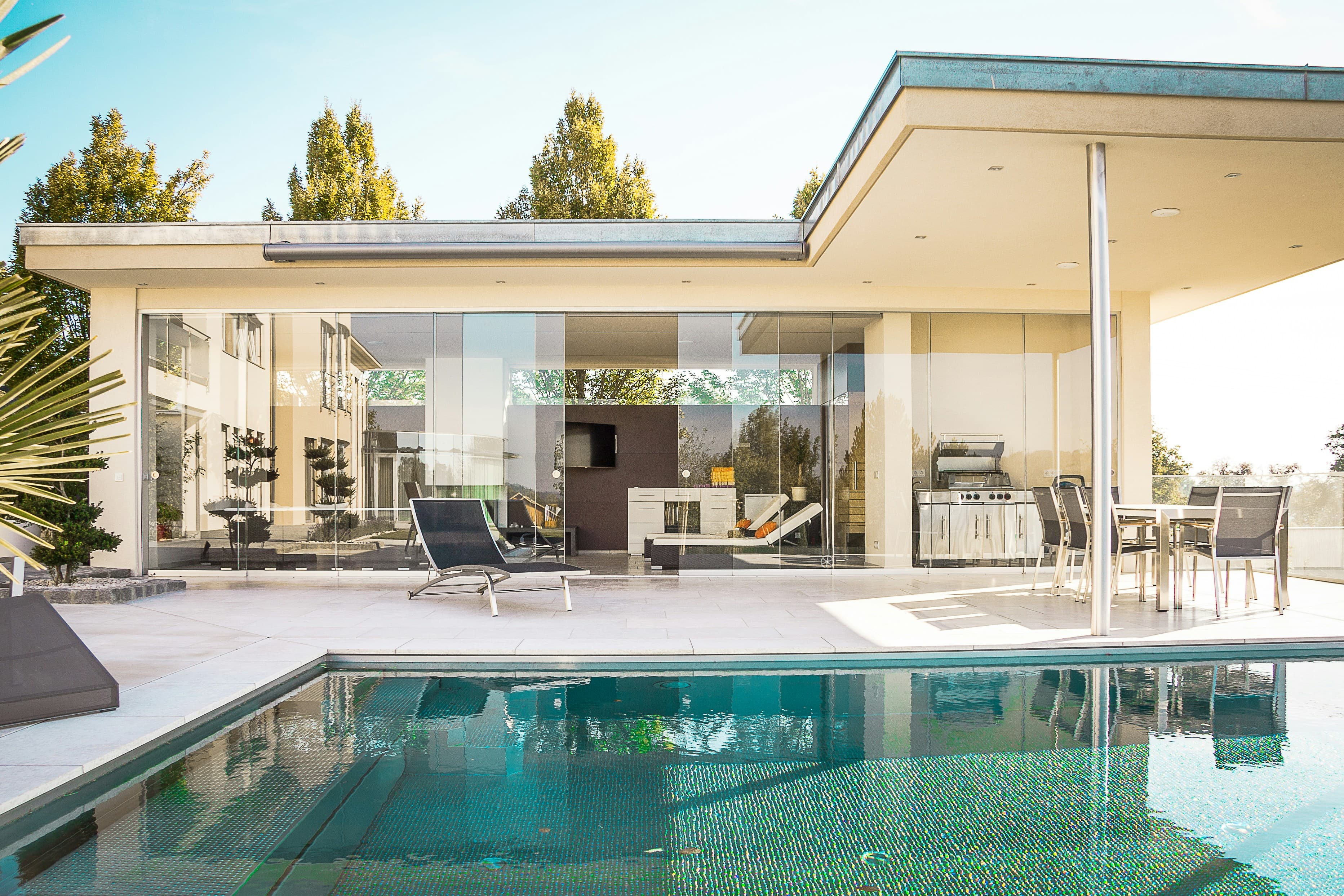 Glass-walled pavilion villa reflected in its pool