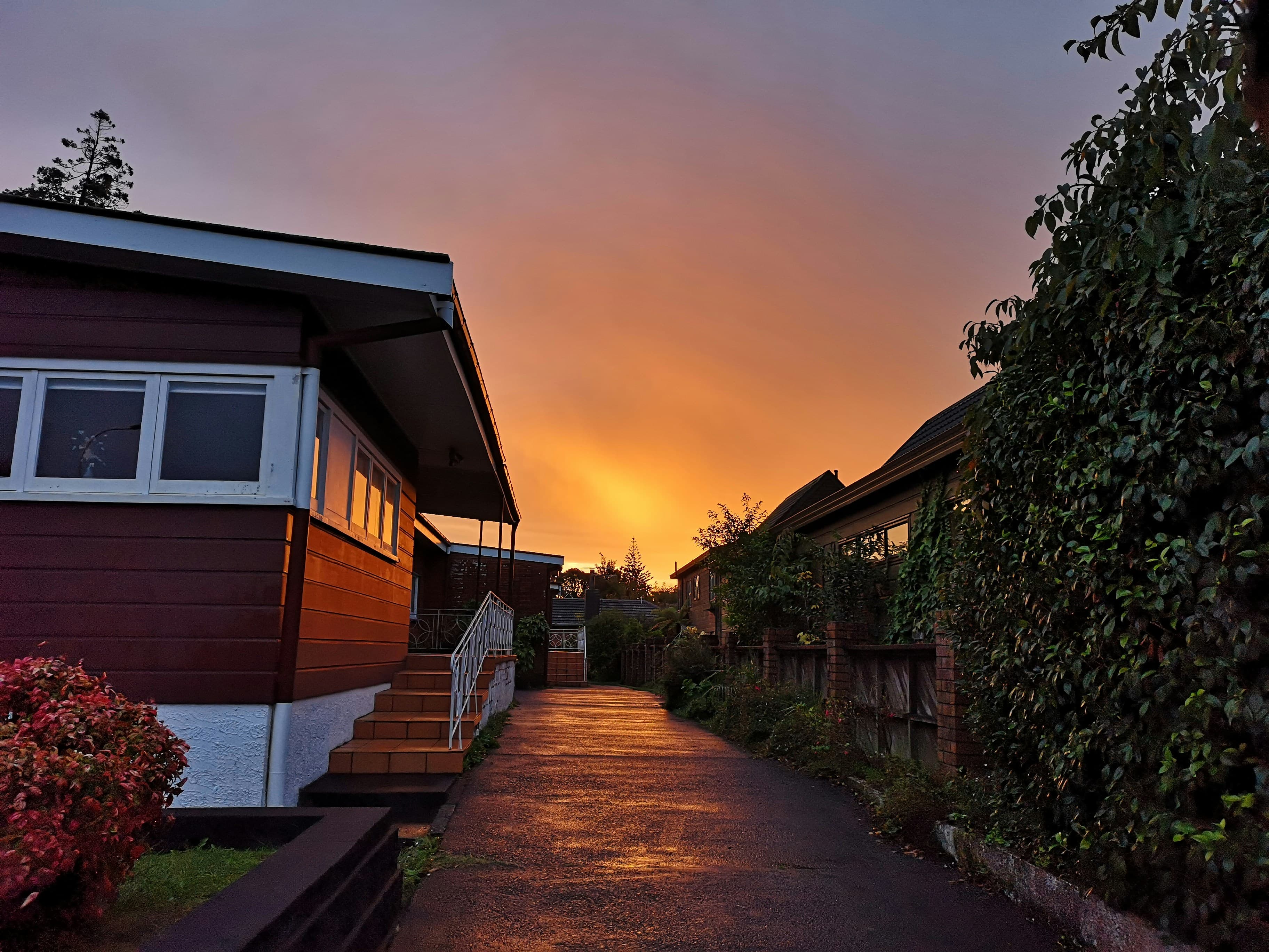 Residential street under a burning sunset sky